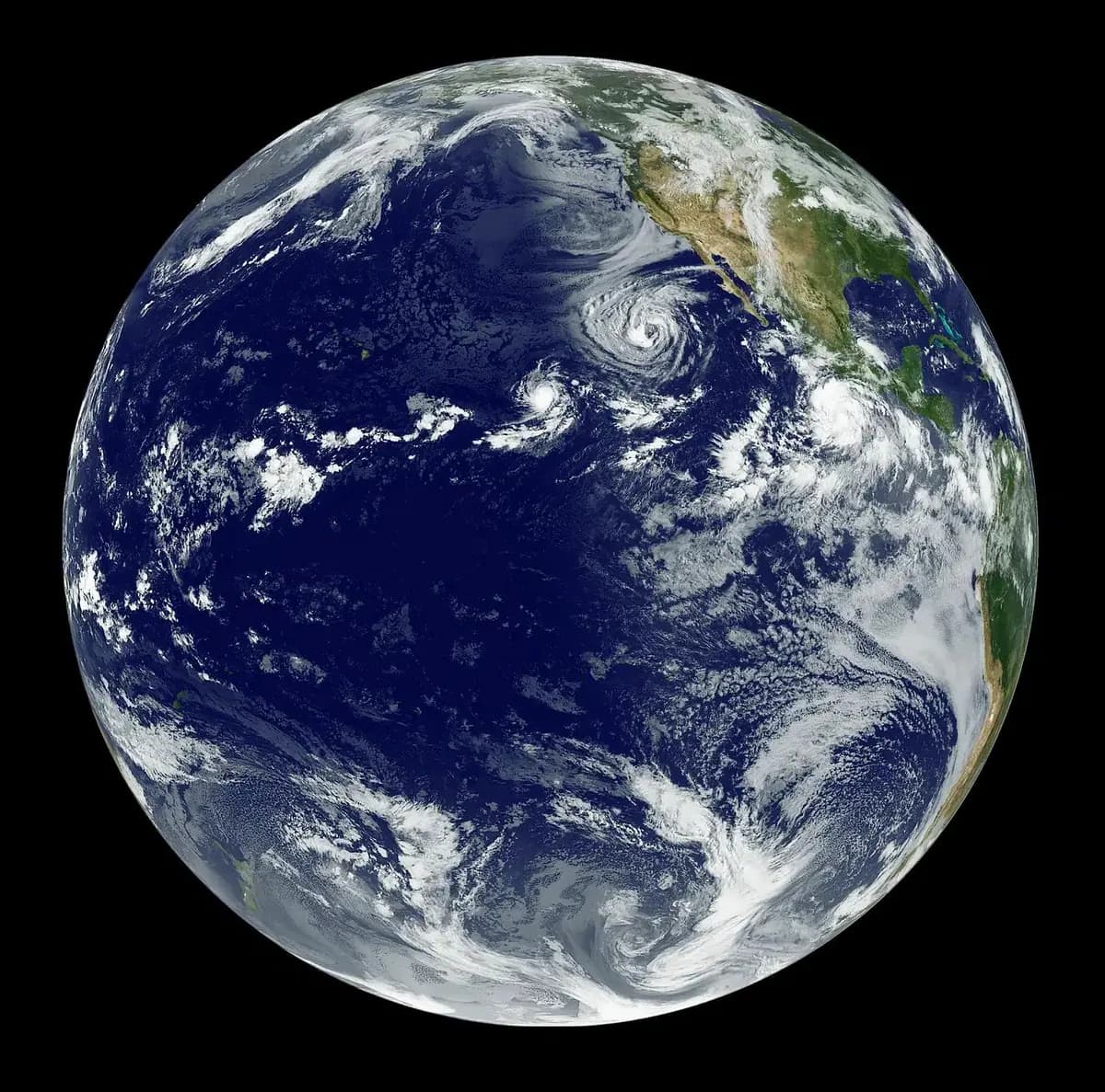 Full-disk view of Earth showing tropical storm systems over the Pacific Ocean